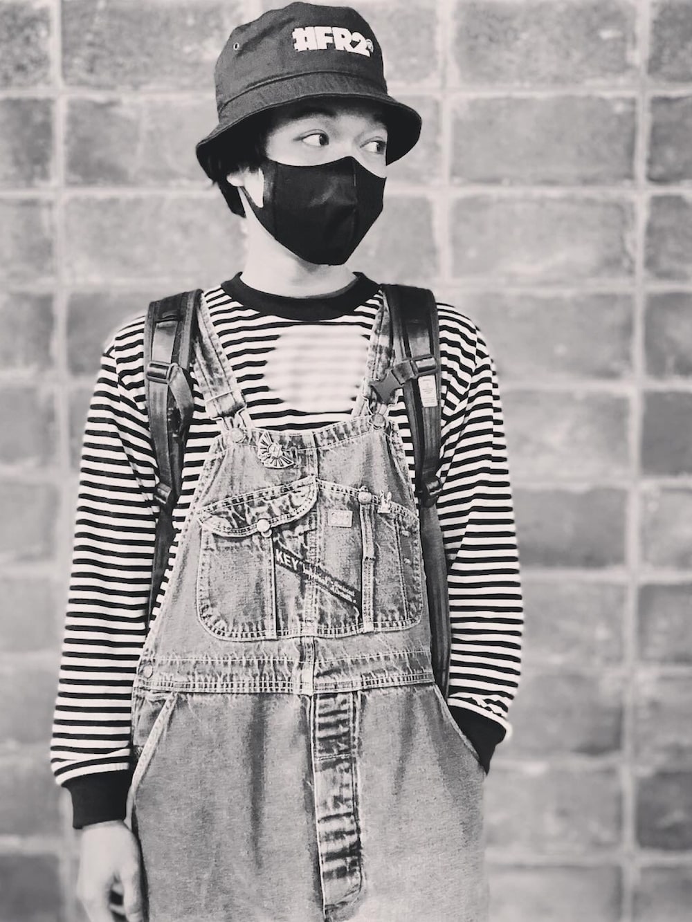 ブラック系のその他シューズ、ブルー系のTシャツ/カットソー、ブラウン系のバックパック/リュックを着用したメンズの冬コーディネートの5枚目の写真