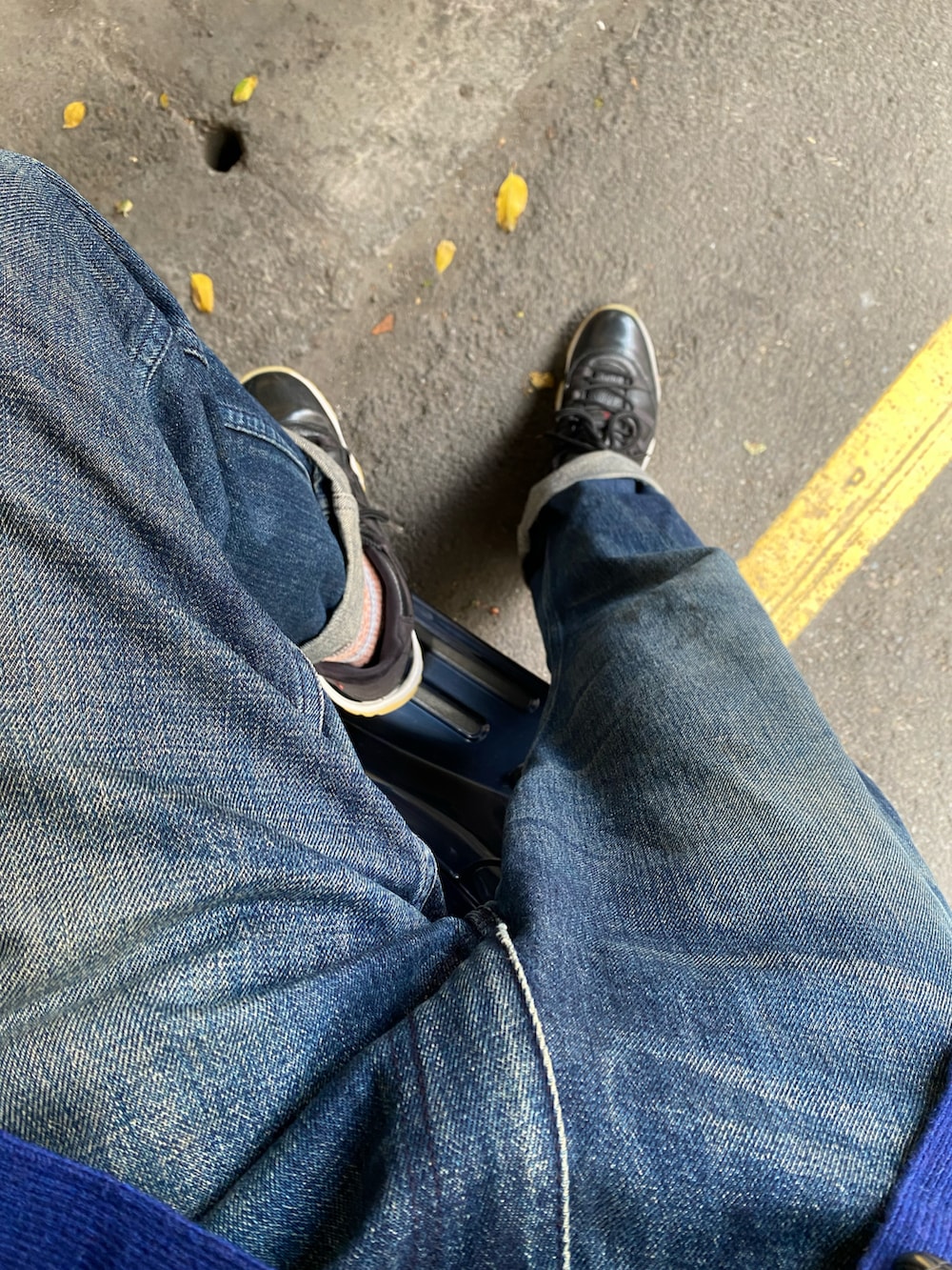 ブルー系のデニムパンツ、ブラック系のスニーカー、ブルー系のニット/セーターを着用したメンズの秋コーディネートの3枚目の写真