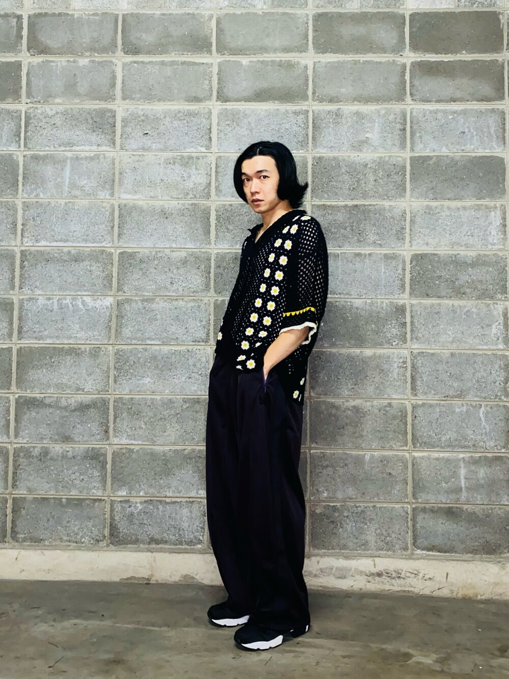 パープル系のパンツ、ブラック系のスニーカー、ブラック系のニット/セーターを着用したメンズの秋コーディネートの2枚目の写真