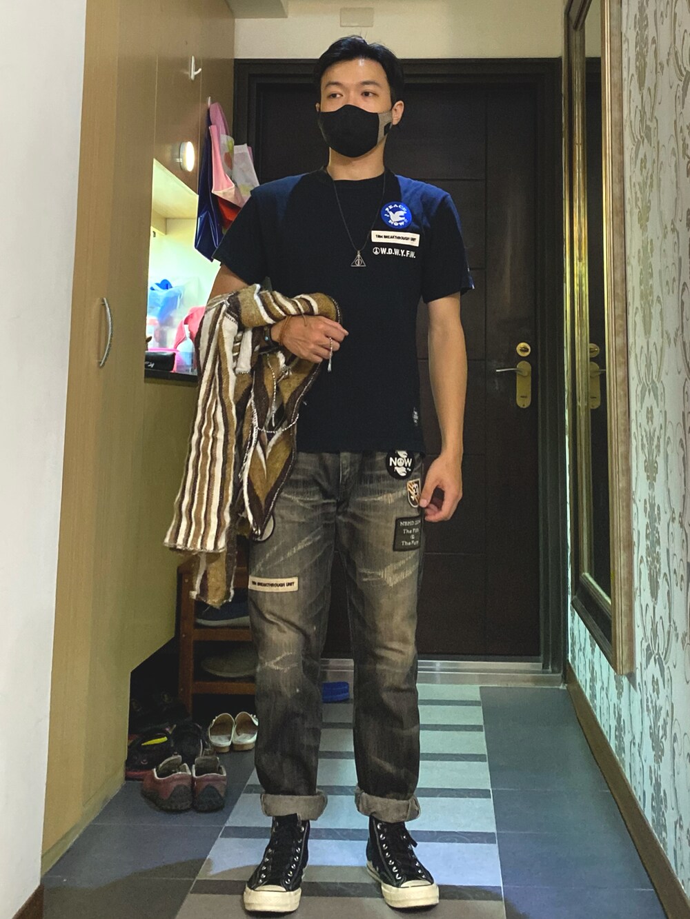 ブラック系のデニムパンツ、ブラック系のスニーカー、ブラック系のTシャツ/カットソーを着用したメンズの秋コーディネートの3枚目の写真