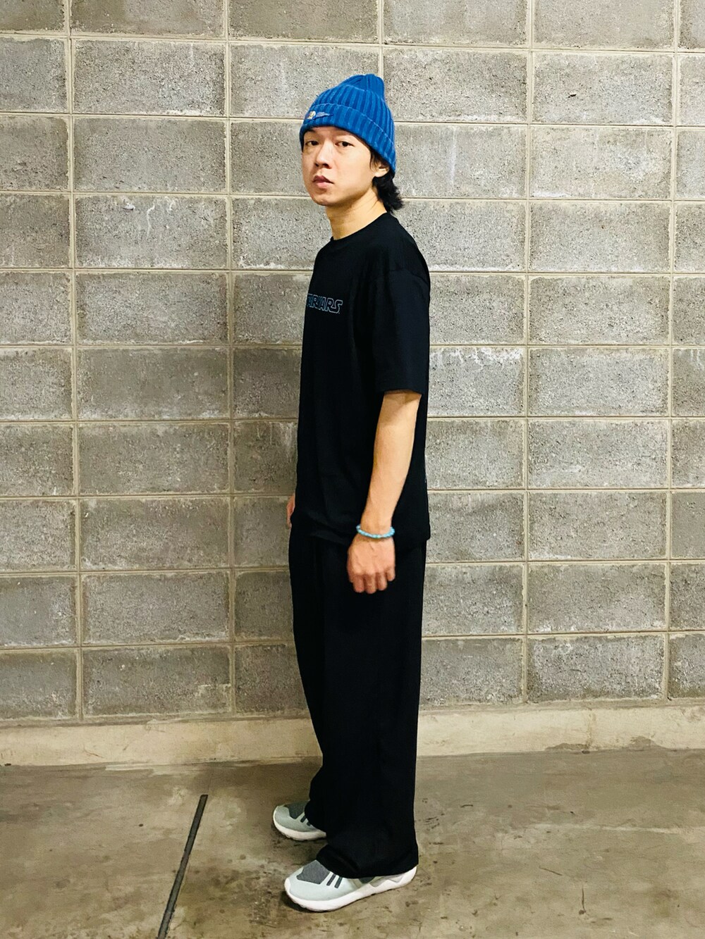 ブラック系のTシャツ/カットソー、ブラック系のパンツ、グレー系のスニーカーを着用したメンズの夏コーディネートの3枚目の写真