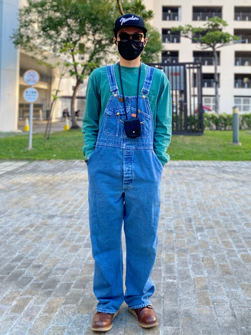 ブラウン系のブーツ、ブルー系のサロペット/オーバーオール、グリーン系のTシャツ/カットソーを着用したメンズの冬コーディネートの4枚目の写真