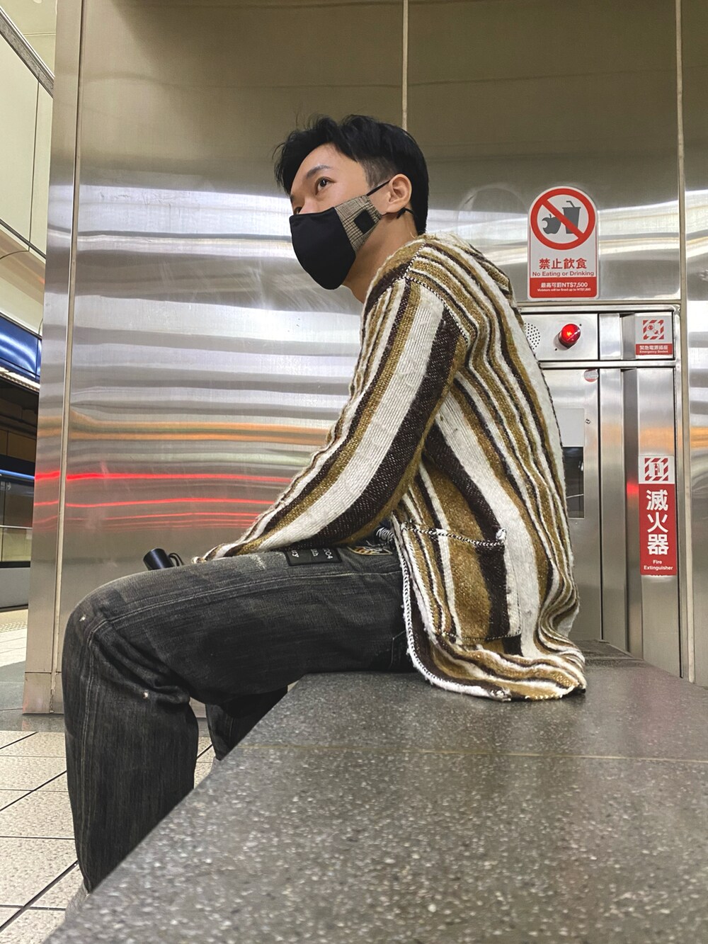 ブラック系のデニムパンツ、ブラック系のスニーカー、ブラック系のTシャツ/カットソーを着用したメンズの秋コーディネートの4枚目の写真