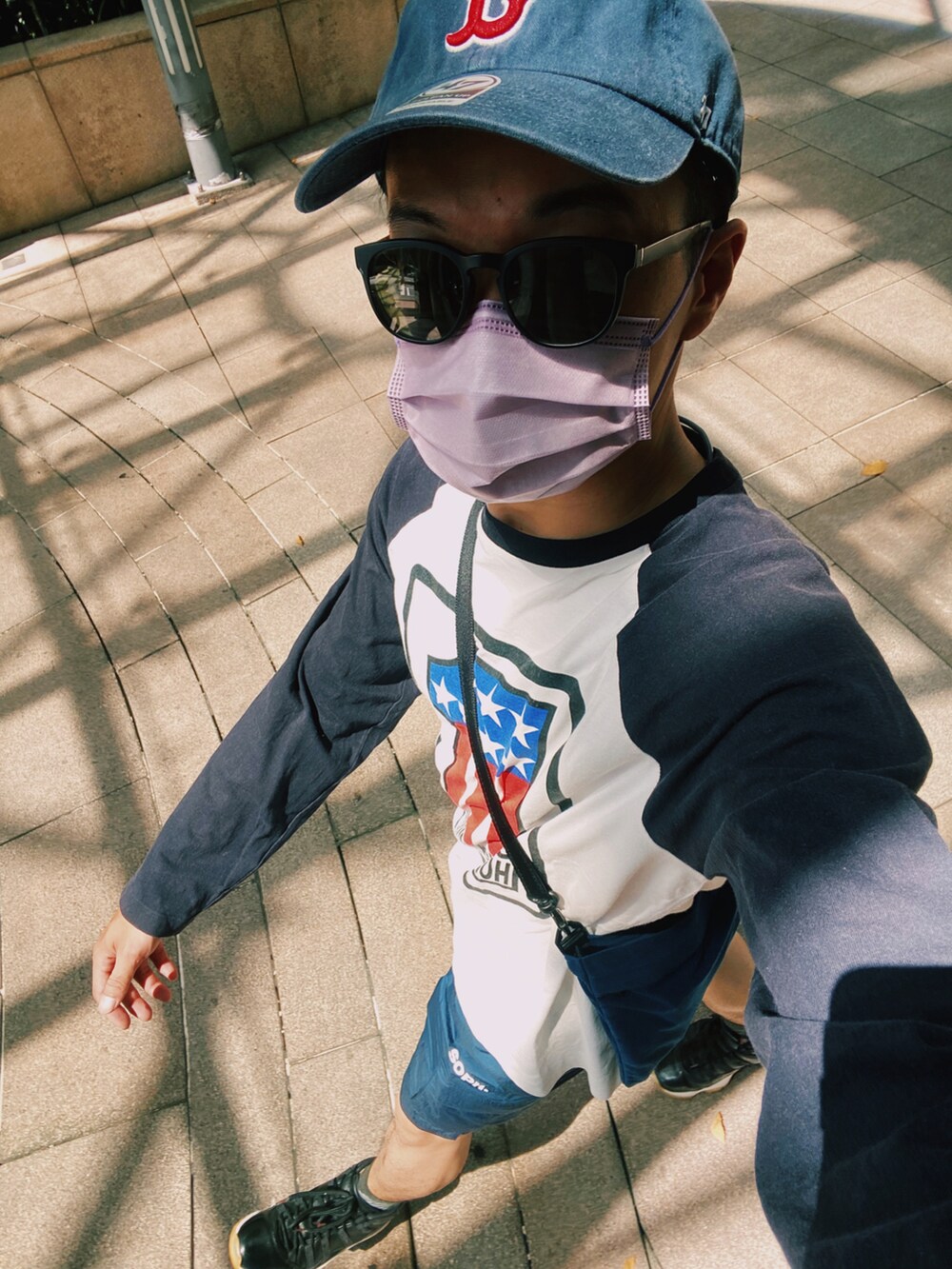 ブルー系のカーゴパンツ、ホワイト系のTシャツ/カットソー、ブラック系のスニーカーを着用したメンズの夏コーディネートの3枚目の写真