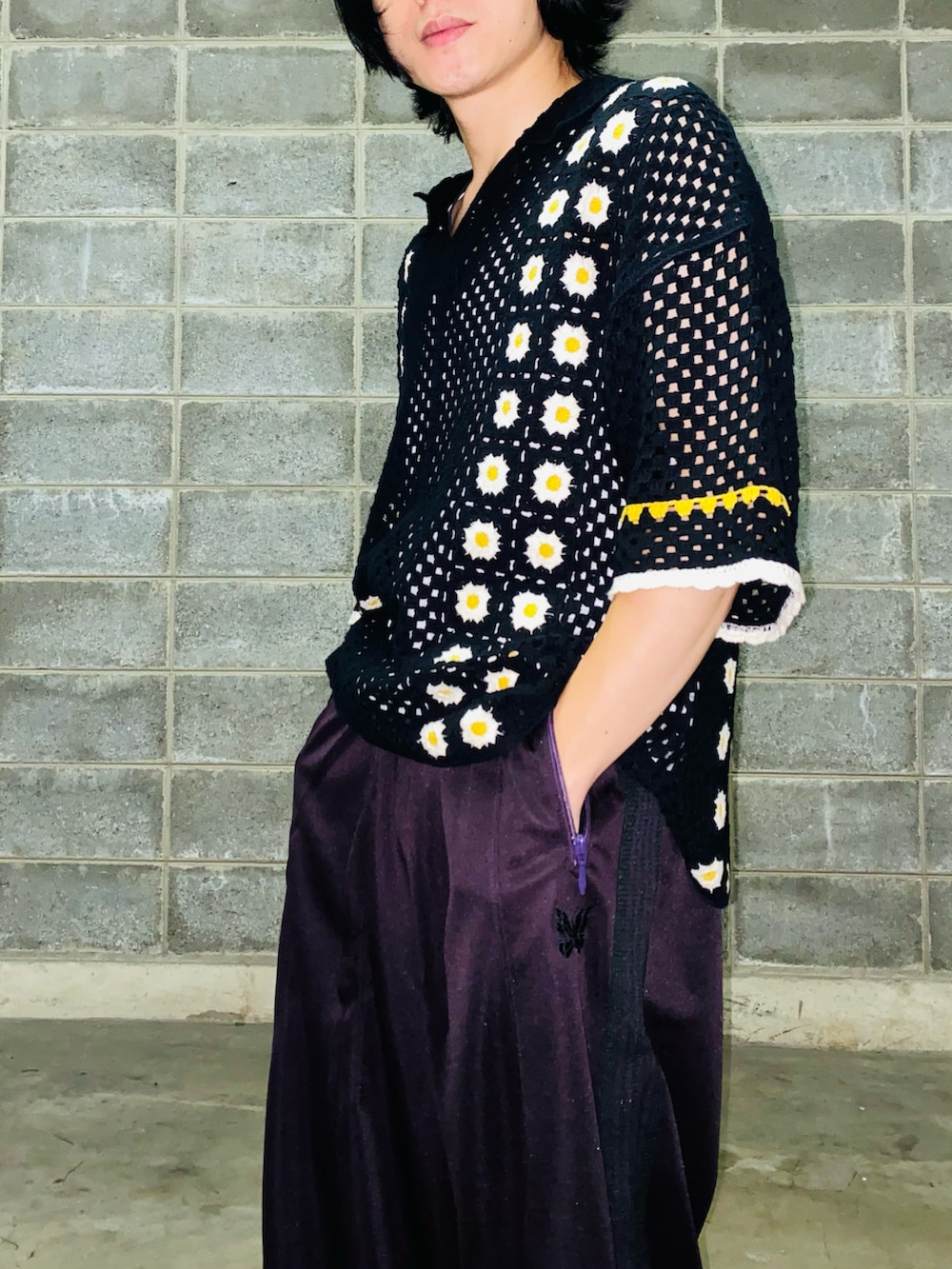 パープル系のパンツ、ブラック系のスニーカー、ブラック系のニット/セーターを着用したメンズの秋コーディネートの3枚目の写真