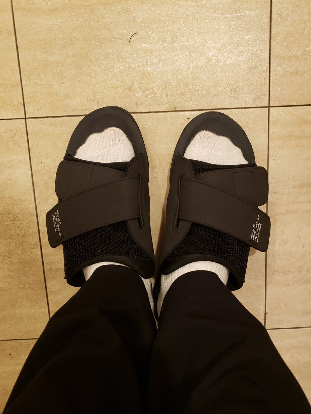 ブラック系のサンダル、ブラック系のTシャツ/カットソー、ブラック系のボディバッグ/ウエストポーチを着用したメンズの春コーディネートの2枚目の写真