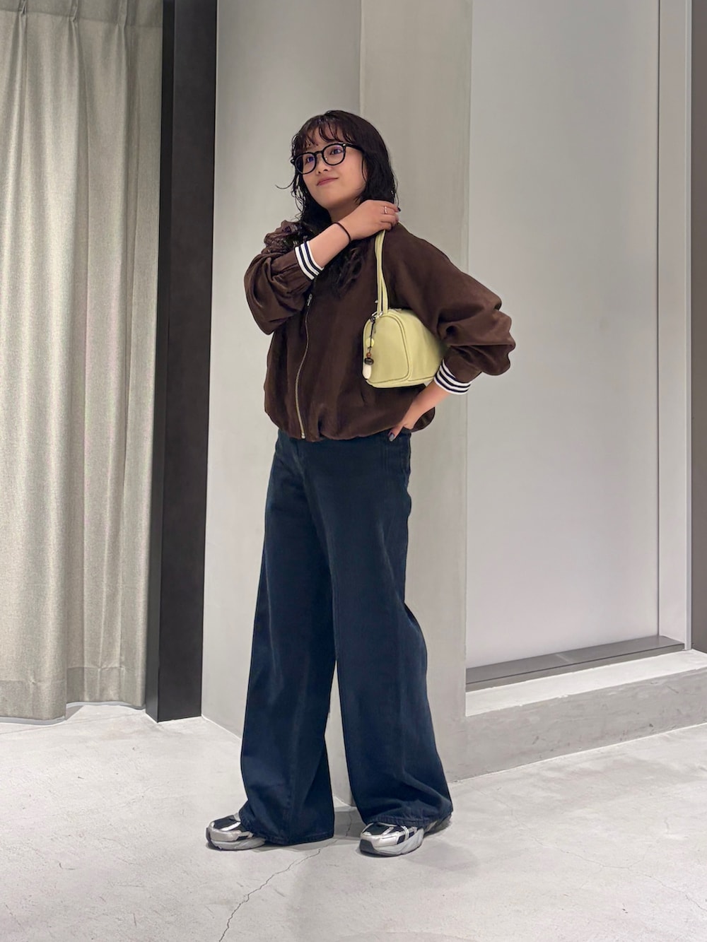 ホワイト系のTシャツ/カットソー、イエロー系のハンドバッグ、ブラウン系のブルゾンを着用したレディースの秋コーディネートの2枚目の写真