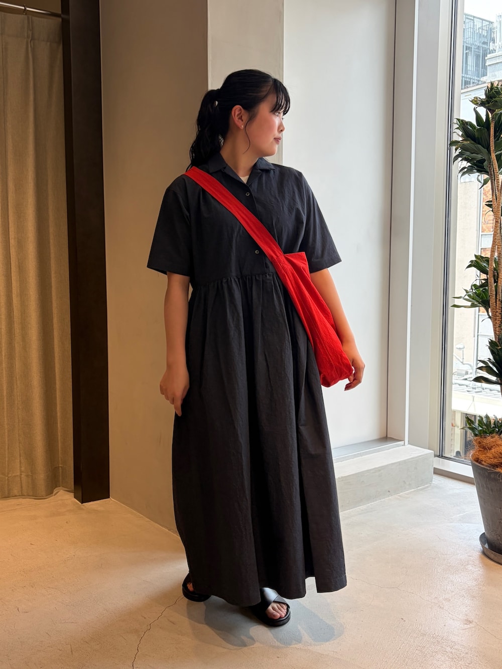 レッド系のショルダーバッグ、ブルー系のワンピース、ブラック系のサンダルを着用したレディースの夏コーディネートの6枚目の写真