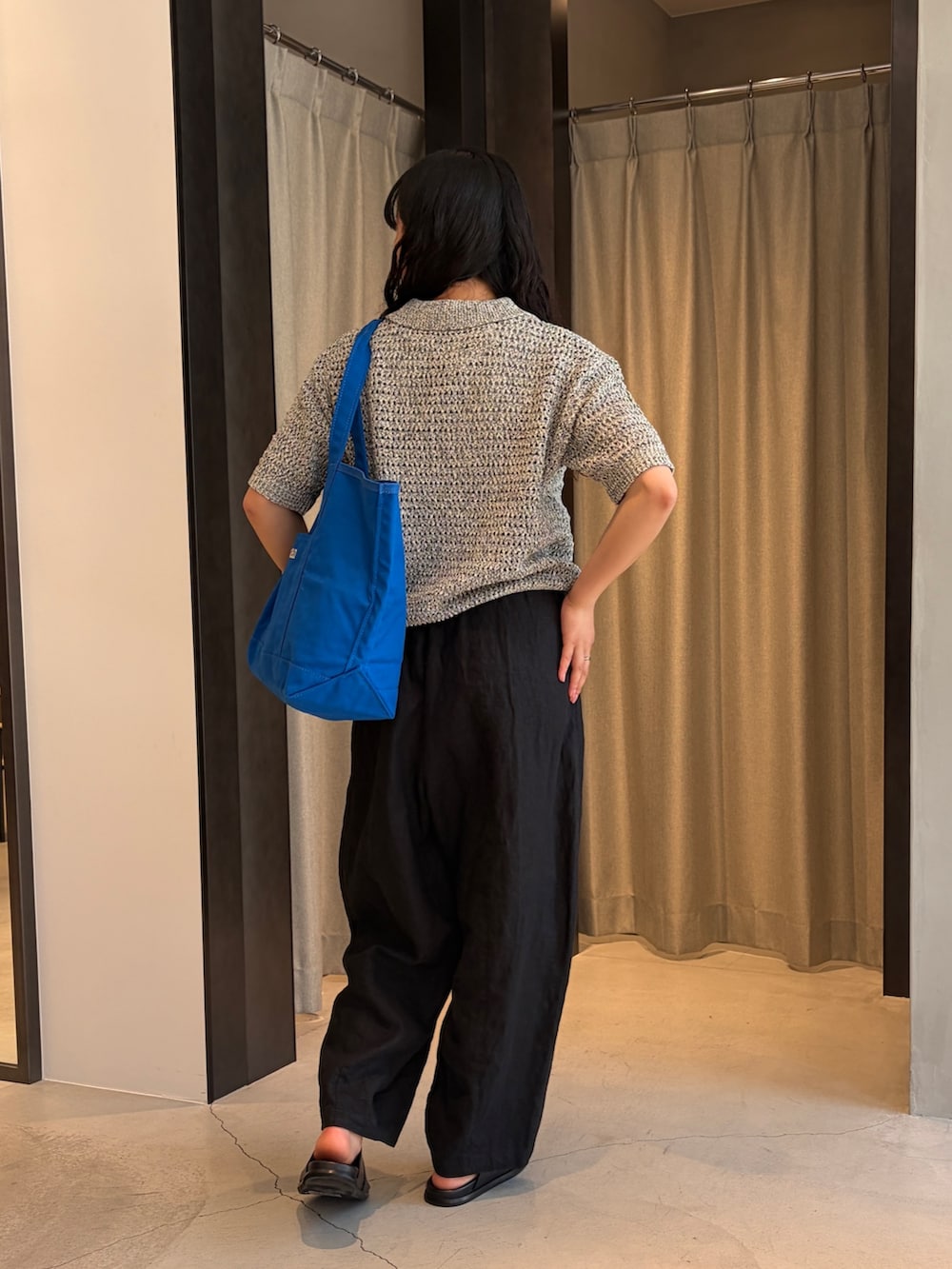 ブルー系のトートバッグ、ブラック系のニット/セーター、ブラック系のその他パンツを着用したレディースの春コーディネートの4枚目の写真