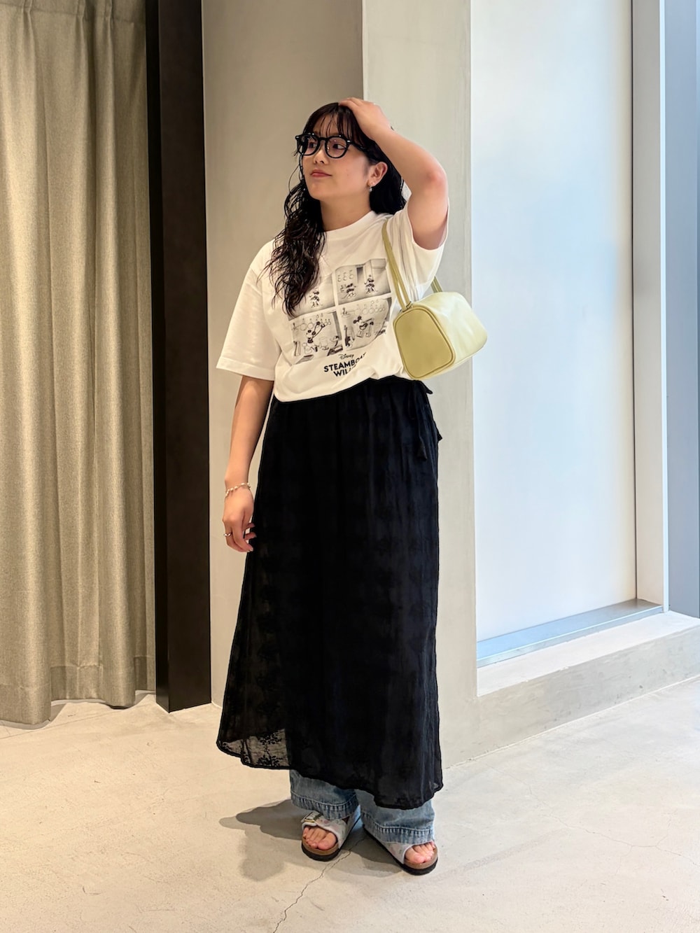 ブラック系のスカート、ブルー系のデニムパンツ、ブルー系のサンダルを着用したレディースの夏コーディネートの2枚目の写真