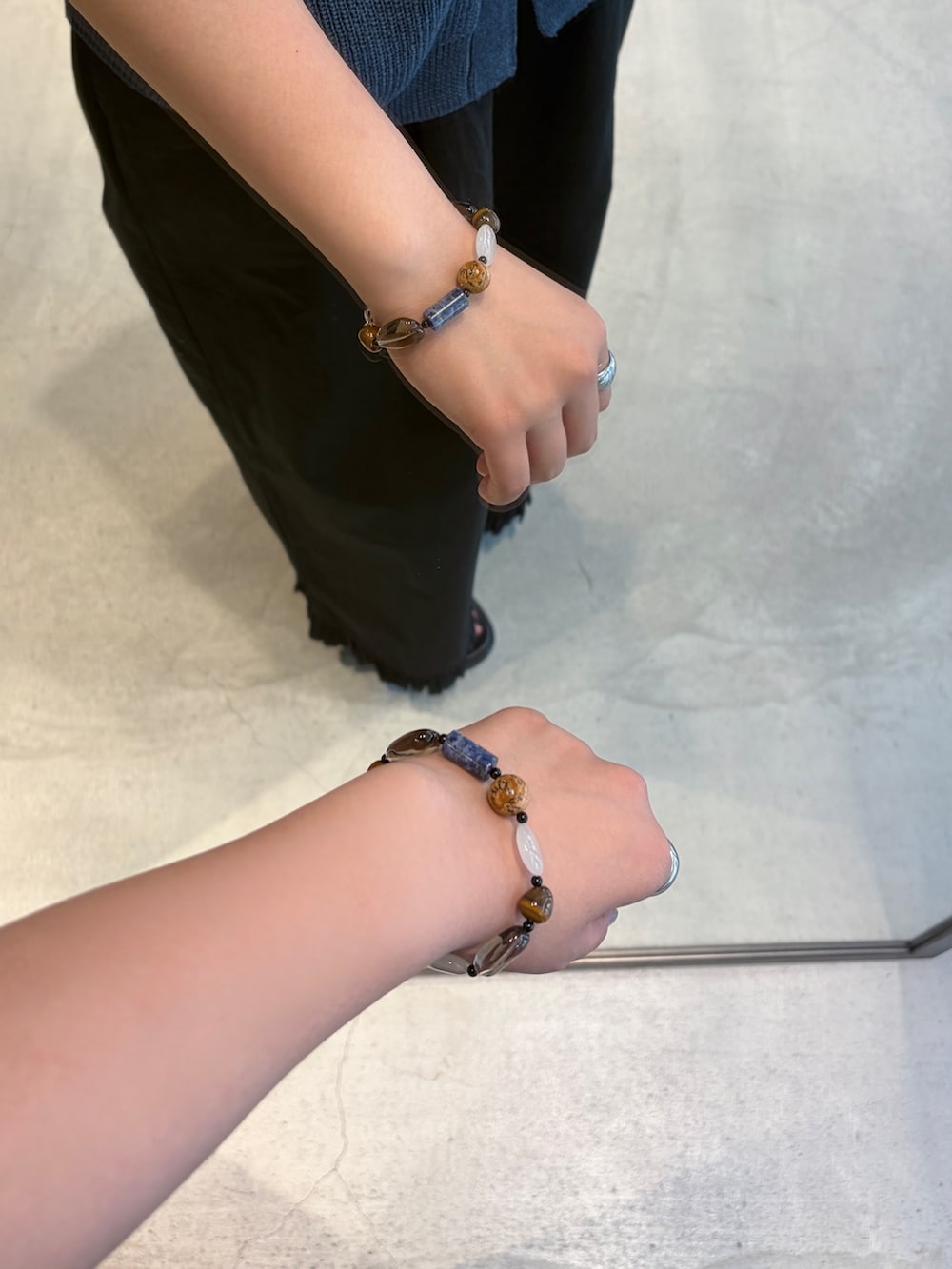ブルー系のベスト、イエロー系のハンドバッグ、ブラック系のその他パンツを着用したレディースの夏コーディネートの6枚目の写真