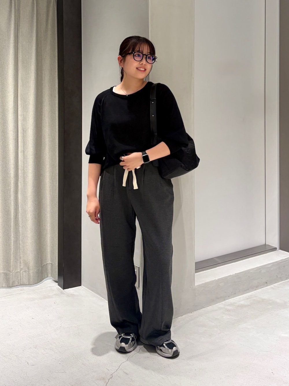 ブラック系のニット/セーター、グレー系のその他パンツ、ブラック系のショルダーバッグを着用したレディースの夏コーディネートの2枚目の写真