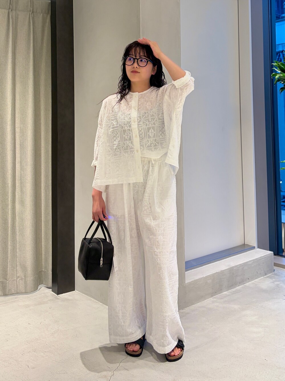 ホワイト系のシャツ/ブラウス、ホワイト系のその他パンツ、ブラック系のハンドバッグを着用したレディースの夏コーディネートの2枚目の写真