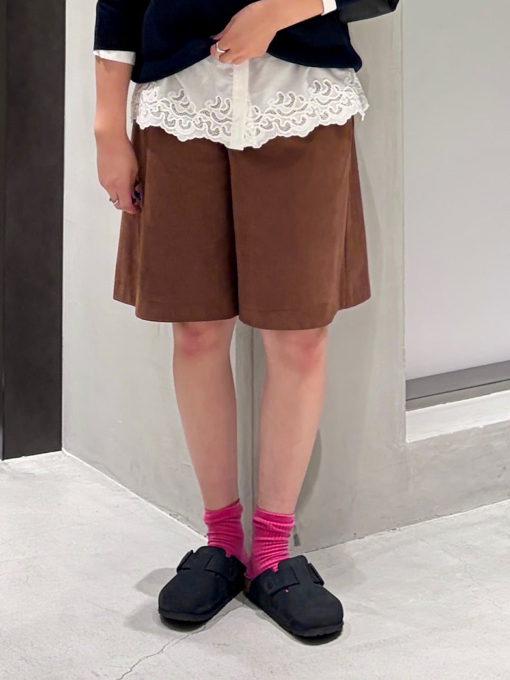 ホワイト系のシャツ/ブラウス、ブルー系のニット/セーター、ブラック系のハンドバッグを着用したレディースの秋コーディネートの4枚目の写真