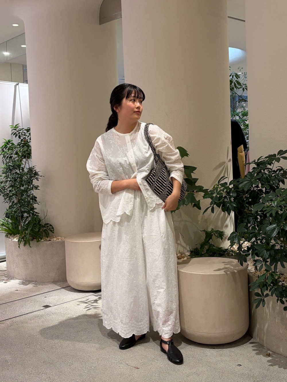 ホワイト系のシャツ/ブラウス、ホワイト系のその他パンツ、ブラック系のサンダルを着用したレディースの春コーディネートの2枚目の写真