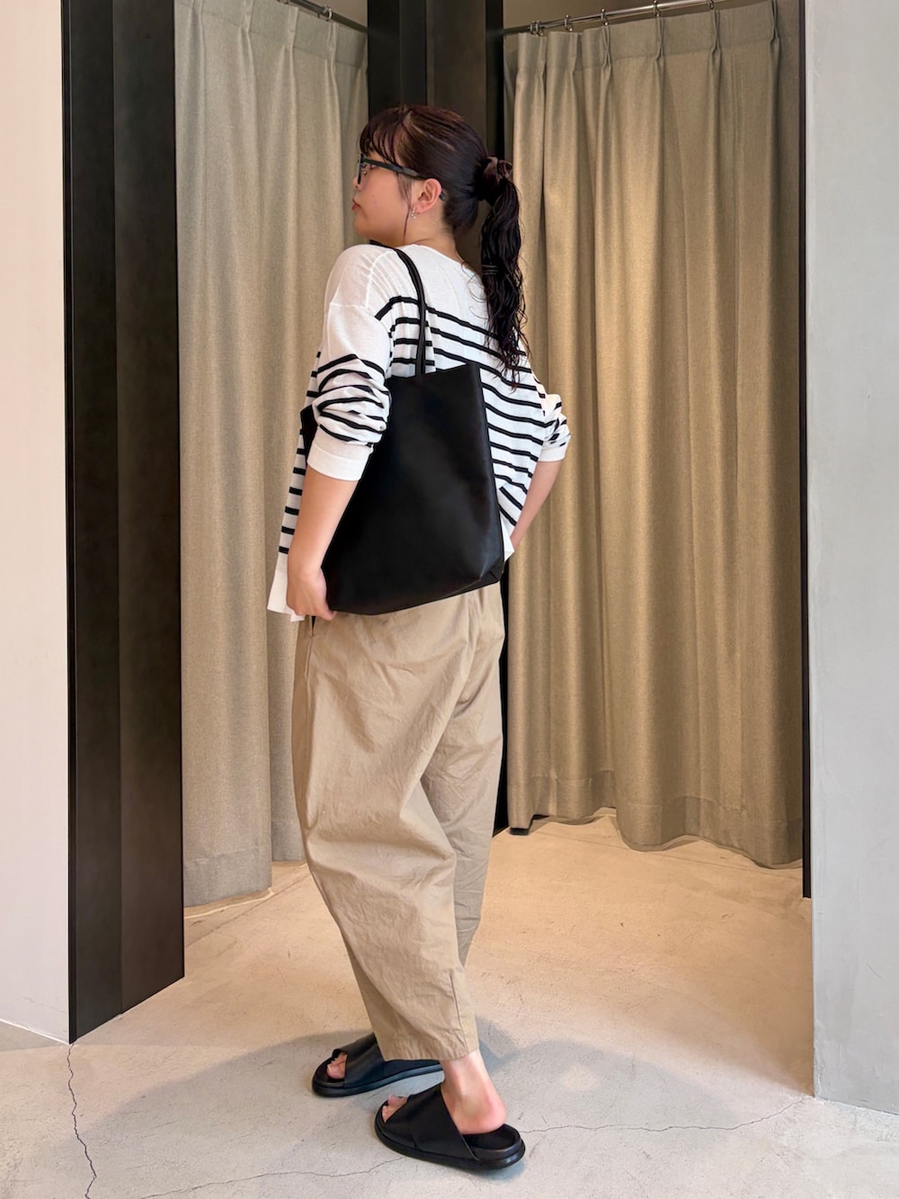 ベージュ系のその他パンツ、ブラック系のサンダル、ブラック系のトートバッグを着用したレディースの夏コーディネートの3枚目の写真