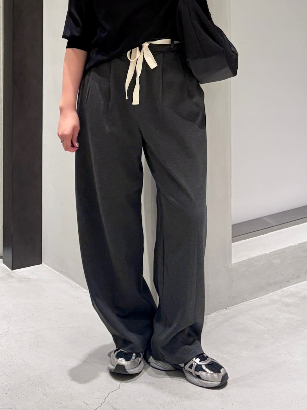 ブラック系のニット/セーター、グレー系のその他パンツ、ブラック系のショルダーバッグを着用したレディースの夏コーディネートの5枚目の写真
