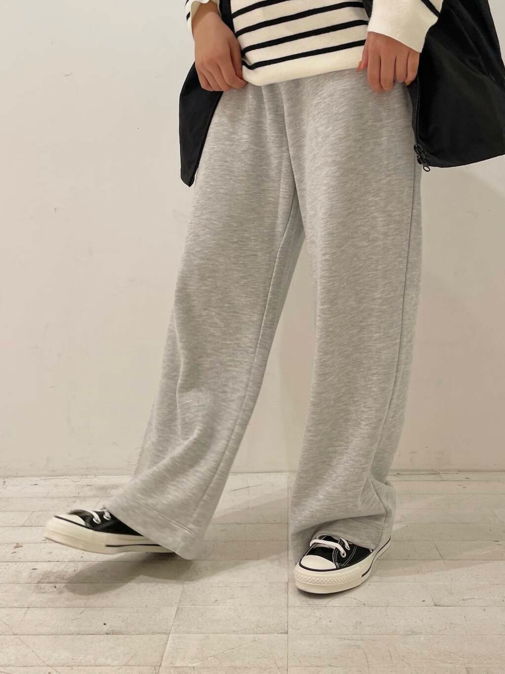 ブラック系のスニーカー、ブラック系のショルダーバッグ、ブラック系のベストを着用したレディースの秋コーディネートの7枚目の写真