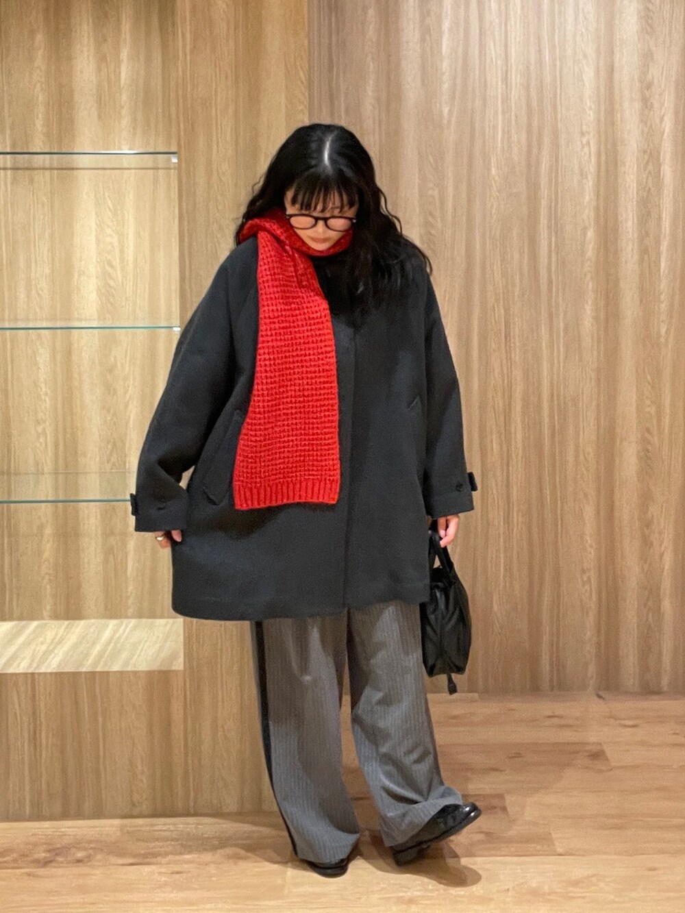 グレー系のステンカラーコート、ブラック系のシャツ/ブラウス、ブラック系のショルダーバッグを着用したレディースの冬コーディネートの2枚目の写真