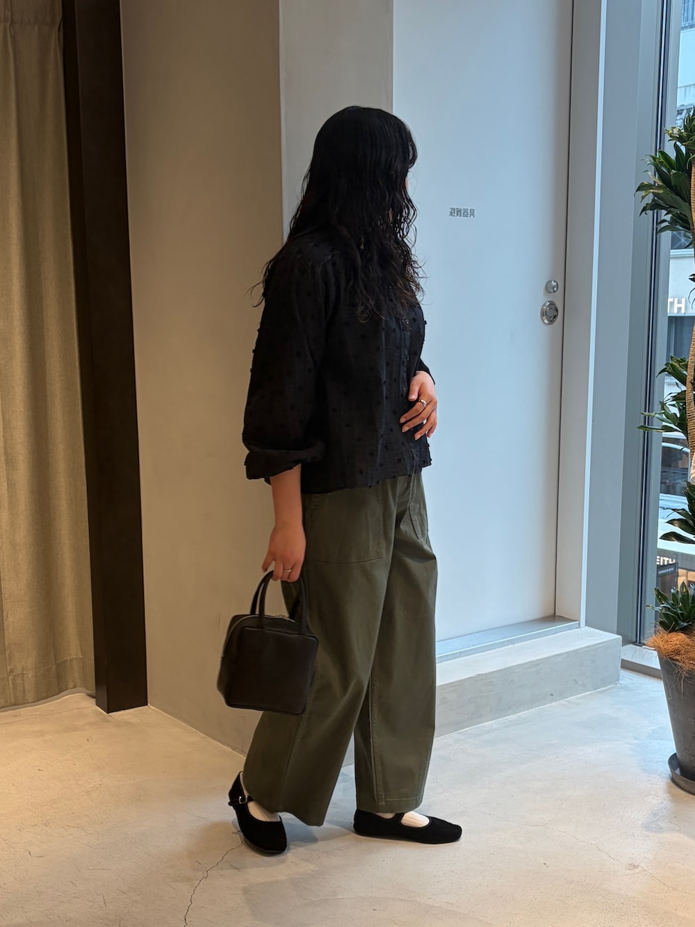 グリーン系のその他パンツ、ブラック系のシャツ/ブラウス、ブラック系のハンドバッグを着用したレディースの春コーディネートの2枚目の写真