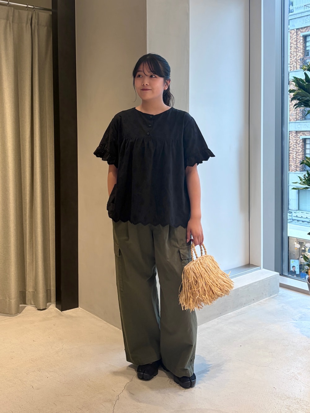ブラック系のシャツ/ブラウス、グリーン系のその他パンツ、ベージュ系のハンドバッグを着用したレディースの夏コーディネートの2枚目の写真