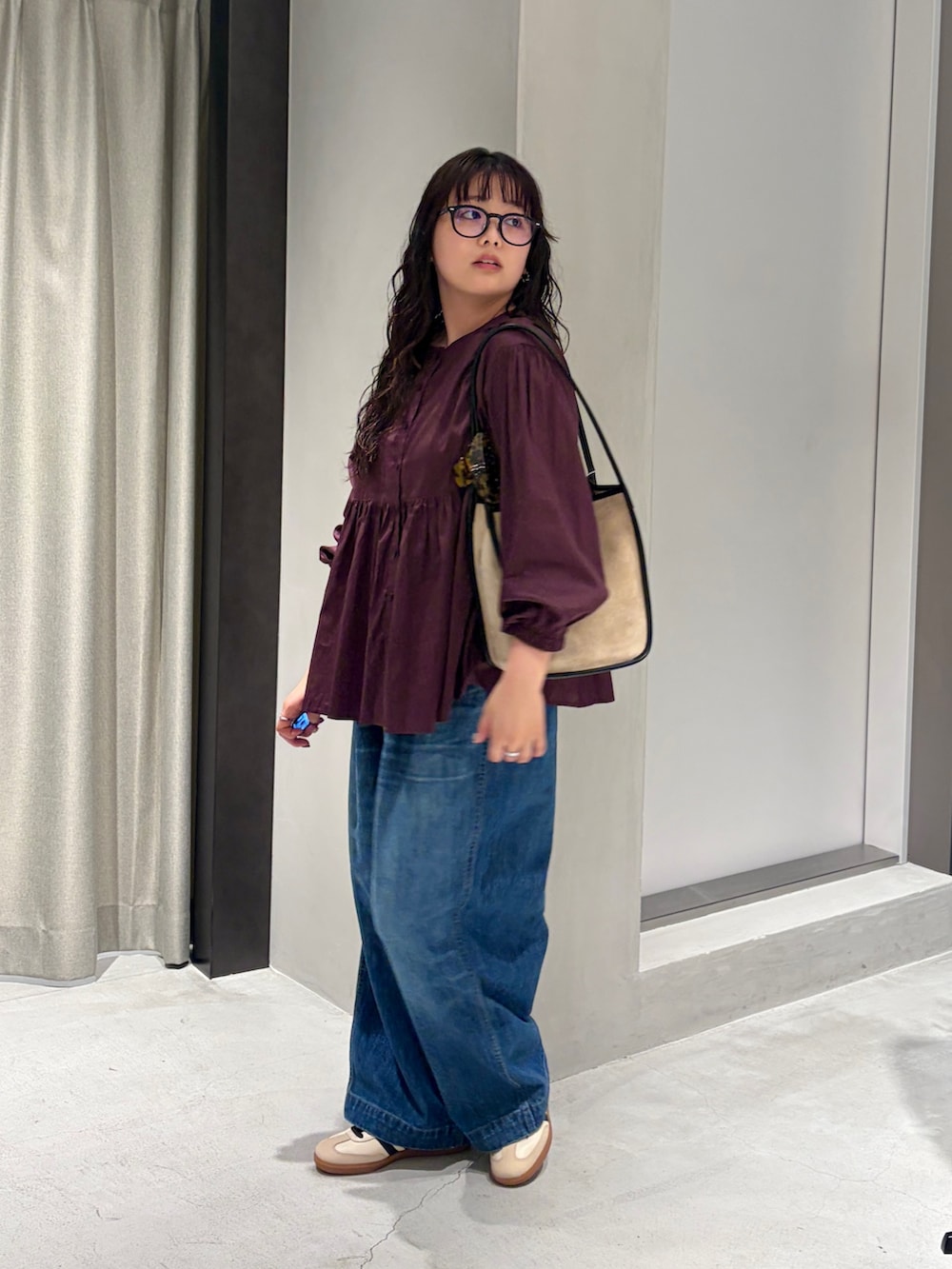 ベージュ系のスニーカー、ブルー系のデニムパンツ、レッド系のシャツ/ブラウスを着用したレディースの秋コーディネートの3枚目の写真