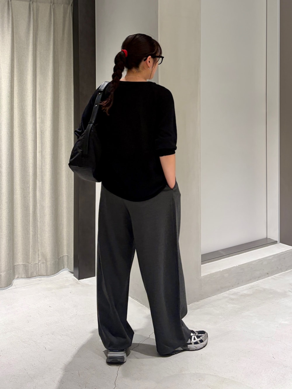 ブラック系のニット/セーター、グレー系のその他パンツ、ブラック系のショルダーバッグを着用したレディースの夏コーディネートの3枚目の写真