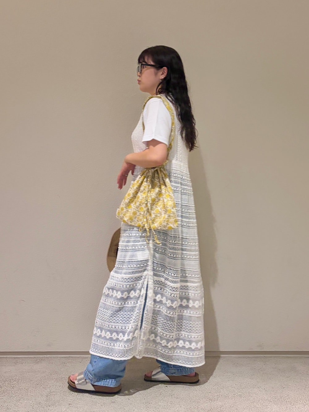 イエロー系のトートバッグ、ホワイト系のTシャツ/カットソー、ホワイト系のワンピースを着用したレディースの夏コーディネートの3枚目の写真