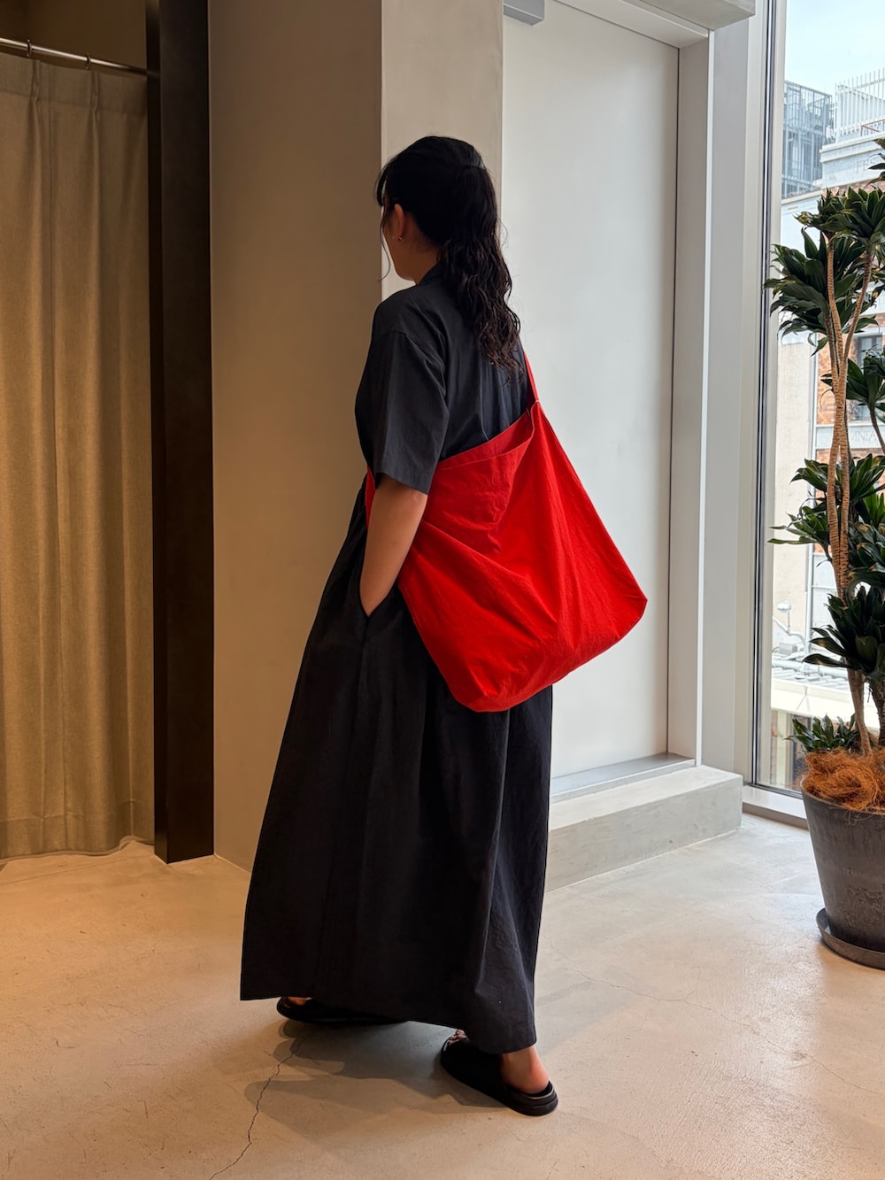 レッド系のショルダーバッグ、ブルー系のワンピース、ブラック系のサンダルを着用したレディースの夏コーディネートの4枚目の写真