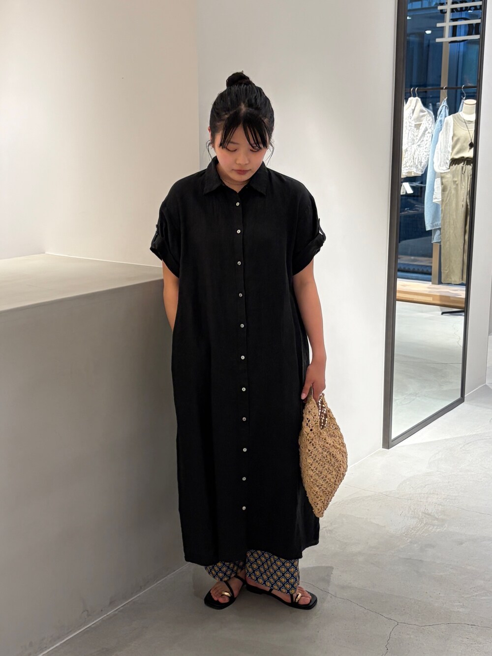 ブラック系のワンピース、ベージュ系のハンドバッグ、ブルー系のその他パンツを着用したレディースの夏コーディネートの2枚目の写真