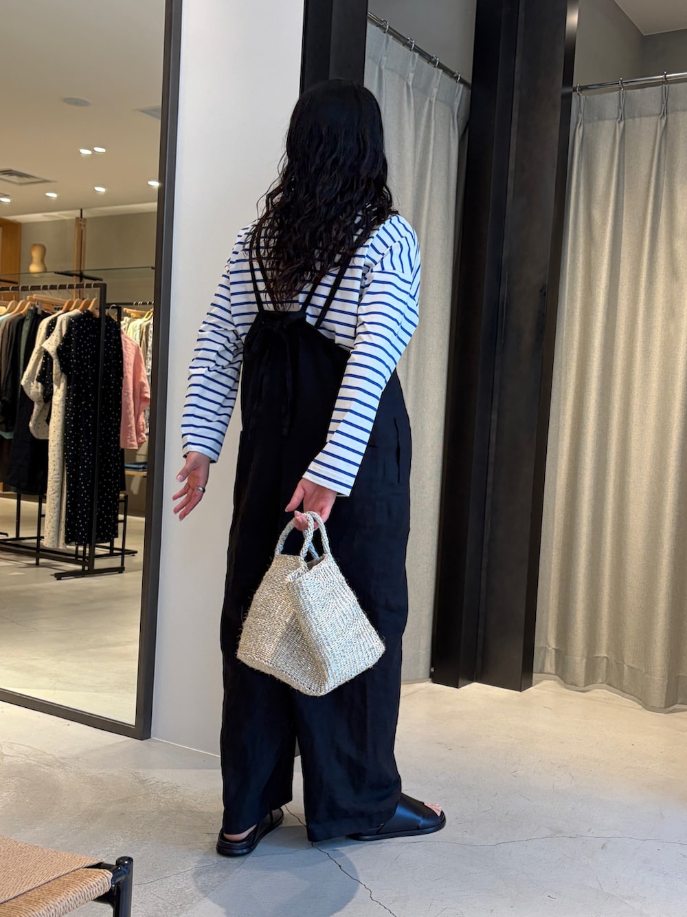 ブラック系のサロペット/オーバーオール、シルバー系のかごバッグ、ブルー系のTシャツ/カットソーを着用したレディースの春コーディネートの5枚目の写真
