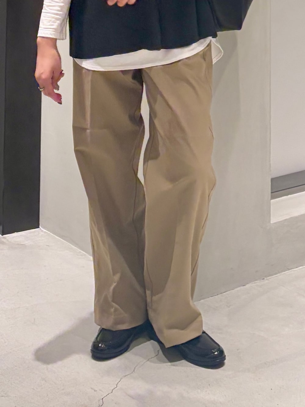 グレー系のベスト、ホワイト系のTシャツ/カットソー、ブラック系のトートバッグを着用したレディースの秋コーディネートの6枚目の写真