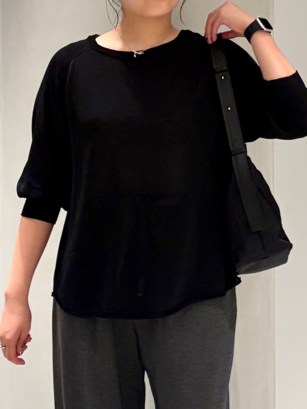 ブラック系のニット/セーター、グレー系のその他パンツ、ブラック系のショルダーバッグを着用したレディースの夏コーディネートの4枚目の写真