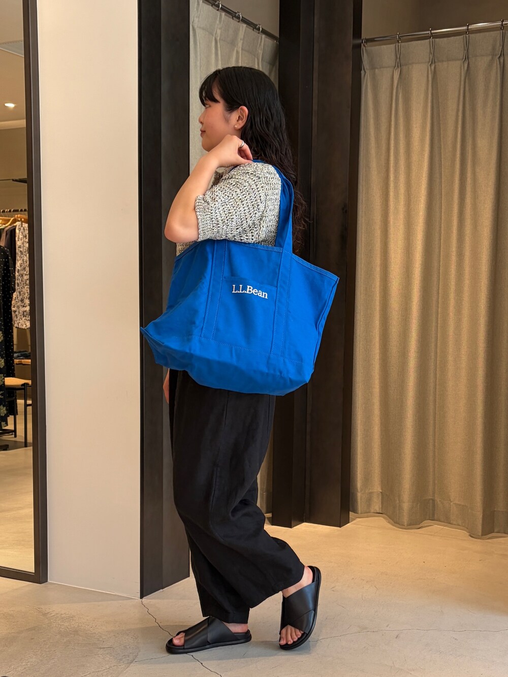 ブルー系のトートバッグ、ブラック系のニット/セーター、ブラック系のその他パンツを着用したレディースの春コーディネートの3枚目の写真