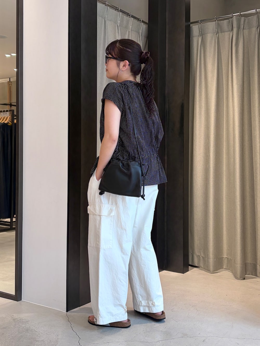 ブラック系のシャツ/ブラウス、ホワイト系のその他パンツ、シルバー系のサンダルを着用したレディースの夏コーディネートの2枚目の写真