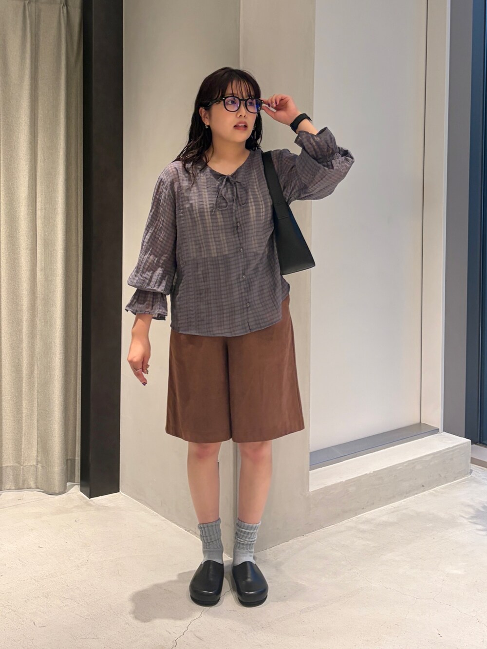 ブルー系のシャツ/ブラウス、ブラック系のハンドバッグ、ブラウン系のその他パンツを着用したレディースの夏コーディネートの4枚目の写真