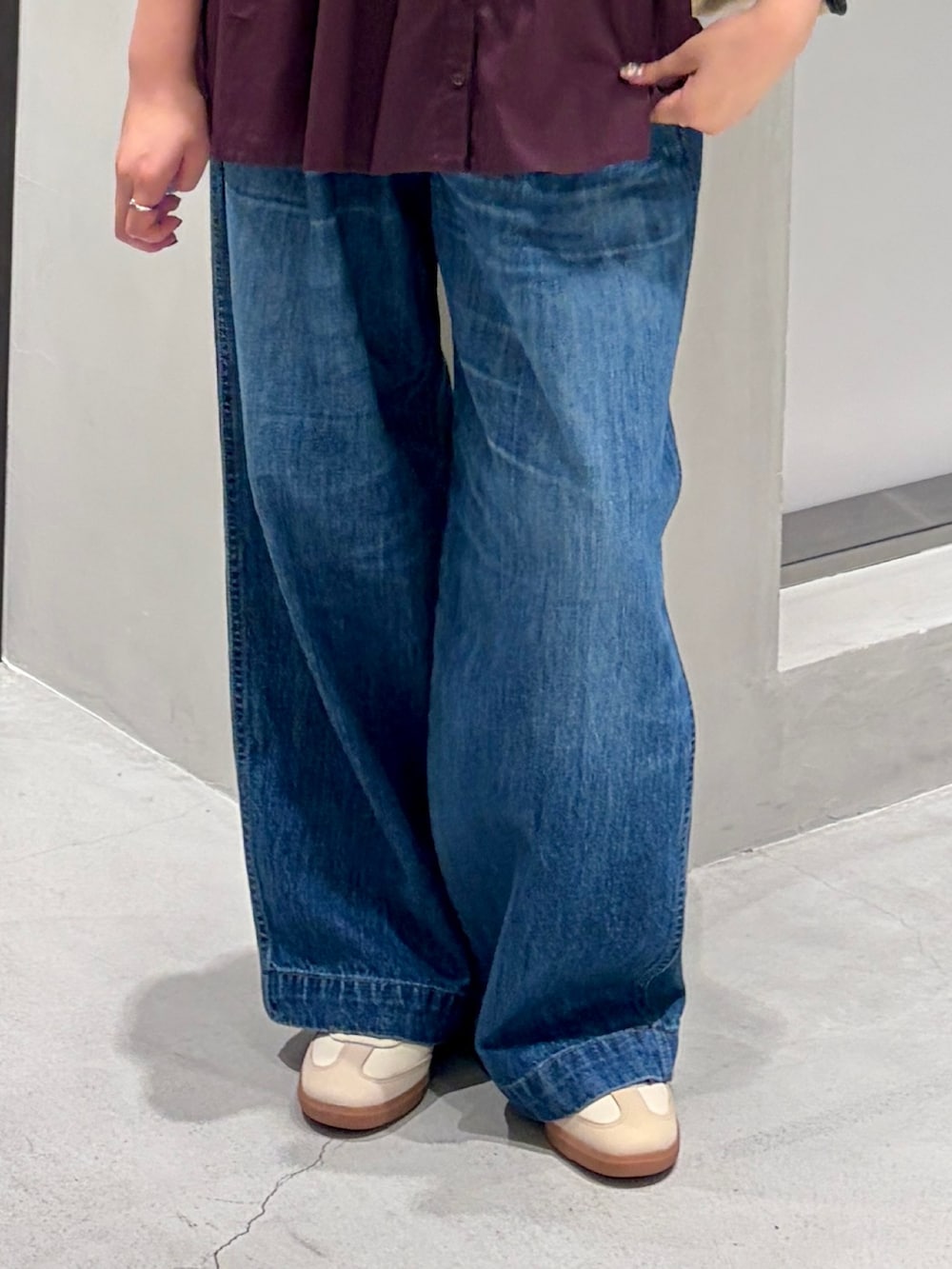 ベージュ系のスニーカー、ブルー系のデニムパンツ、レッド系のシャツ/ブラウスを着用したレディースの秋コーディネートの7枚目の写真