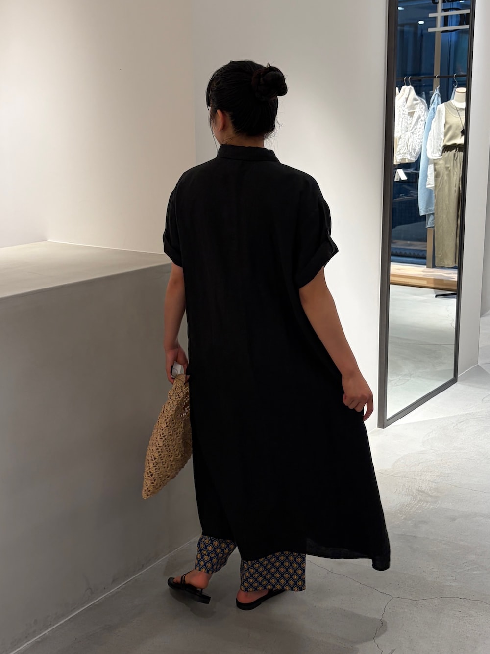 ブラック系のワンピース、ベージュ系のハンドバッグ、ブルー系のその他パンツを着用したレディースの夏コーディネートの3枚目の写真