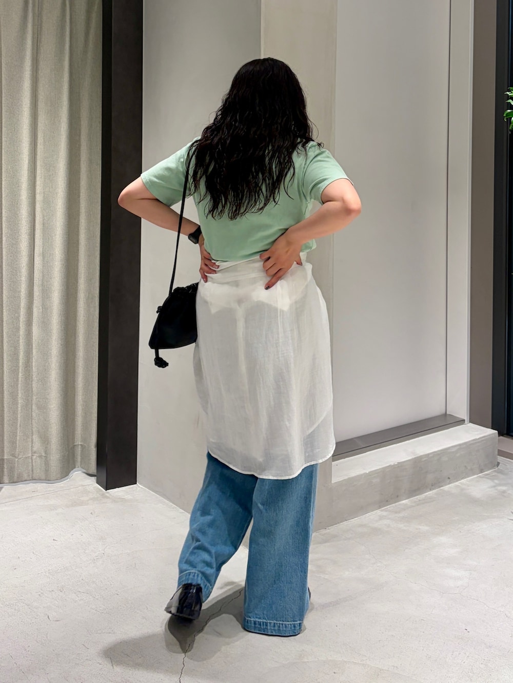 グリーン系のTシャツ/カットソー、ブラック系のショルダーバッグ、ホワイト系のシャツ/ブラウスを着用したレディースの夏コーディネートの4枚目の写真