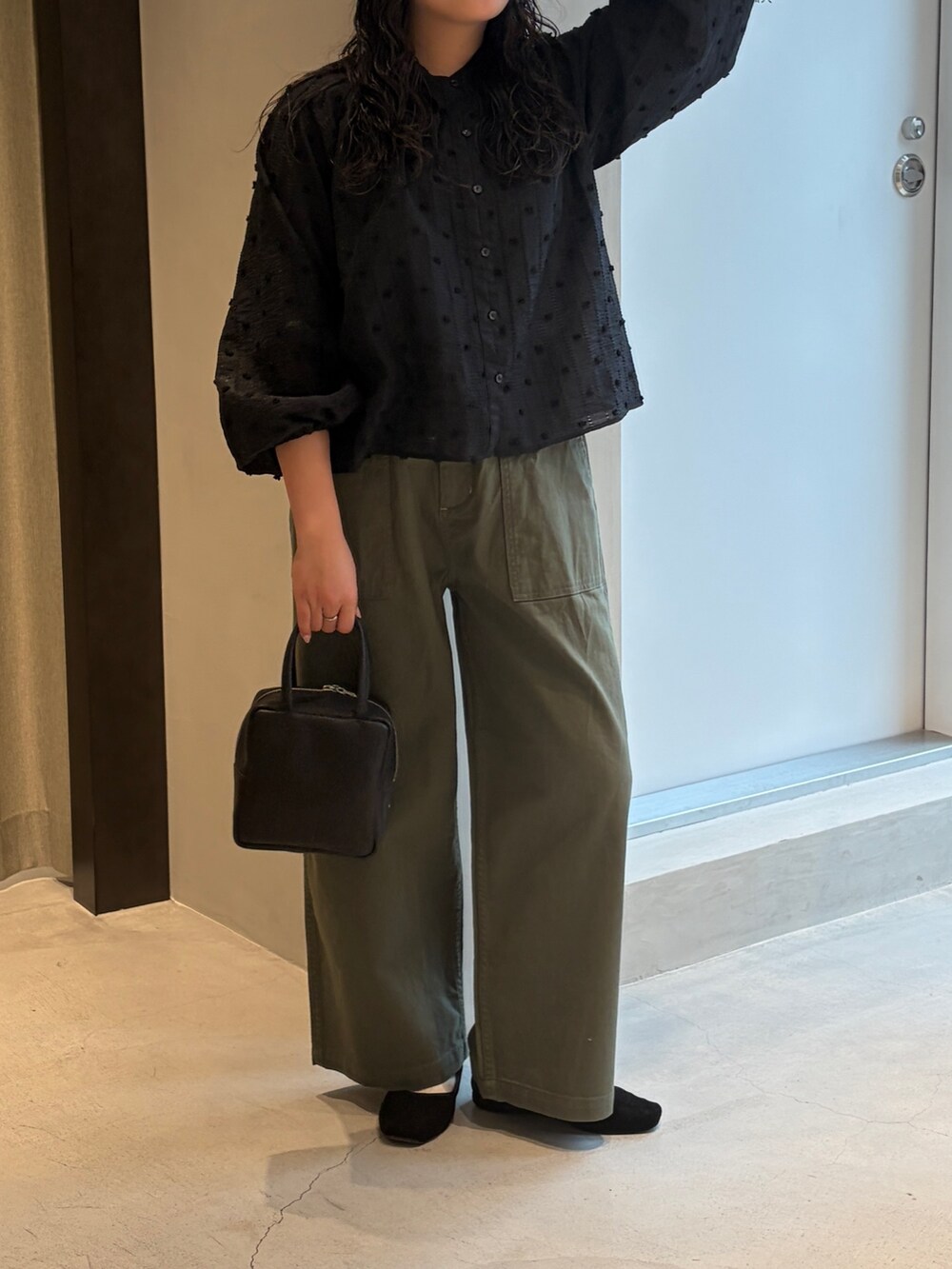 グリーン系のその他パンツ、ブラック系のシャツ/ブラウス、ブラック系のハンドバッグを着用したレディースの春コーディネートの3枚目の写真