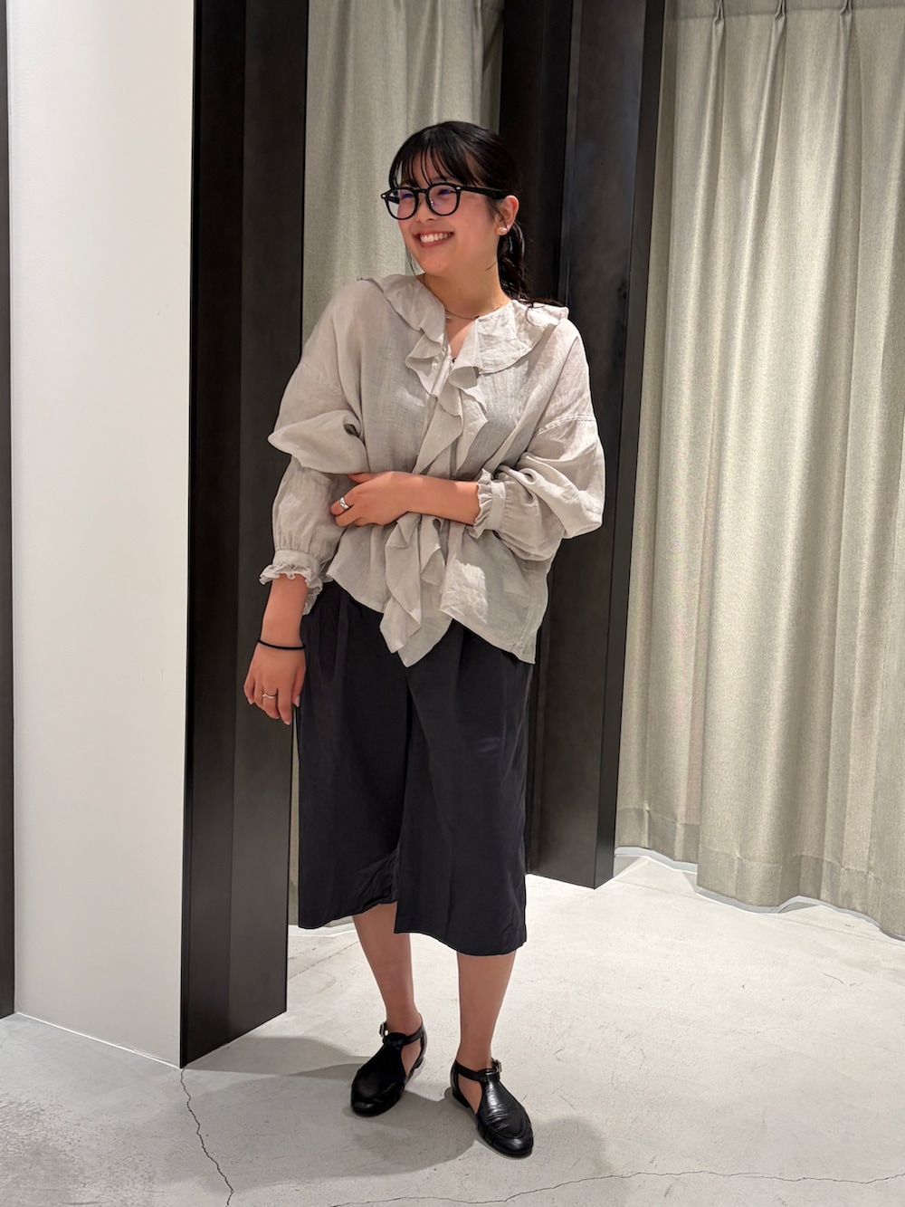 グレー系のシャツ/ブラウス、グレー系のその他パンツ、ブラック系のサンダルを着用したレディースの春コーディネートの2枚目の写真