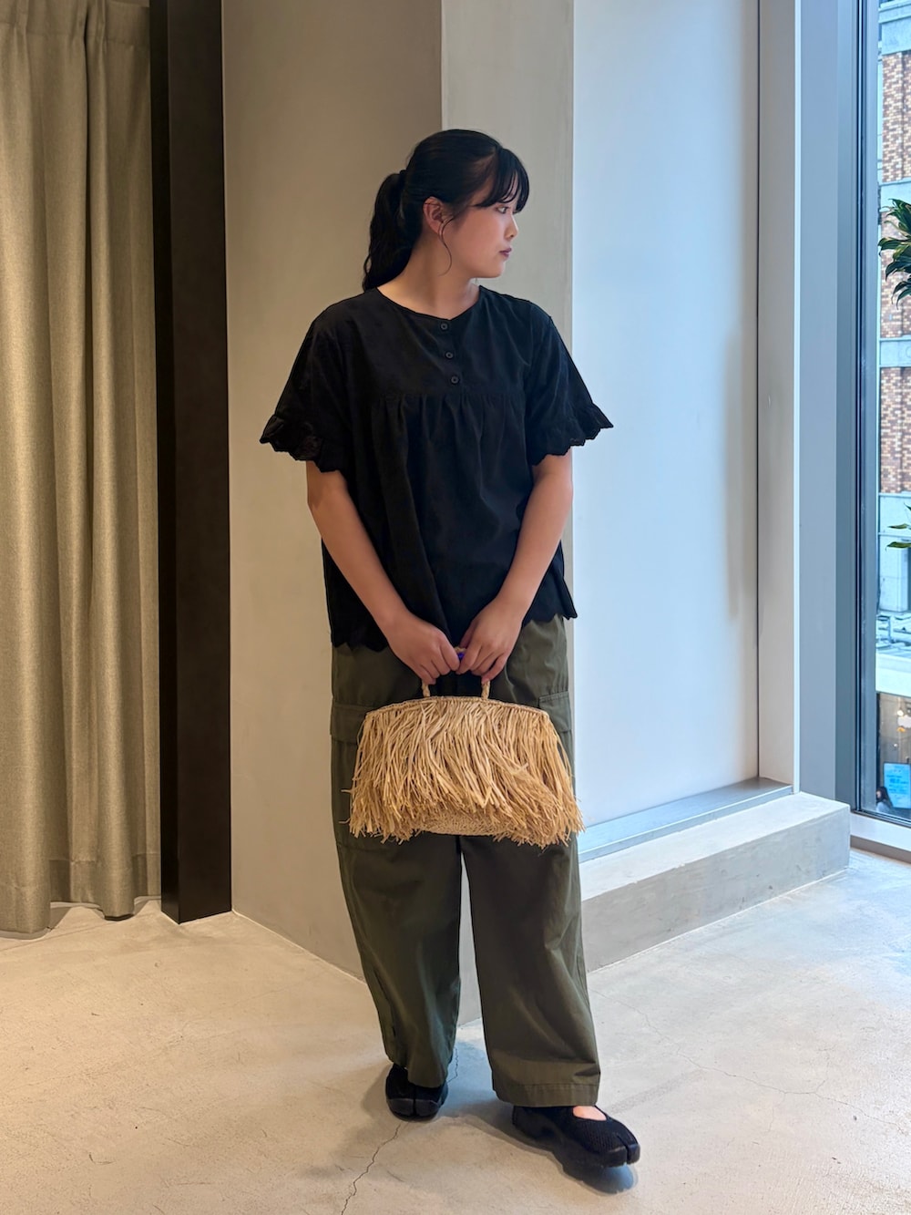 ブラック系のシャツ/ブラウス、グリーン系のその他パンツ、ベージュ系のハンドバッグを着用したレディースの夏コーディネートの4枚目の写真