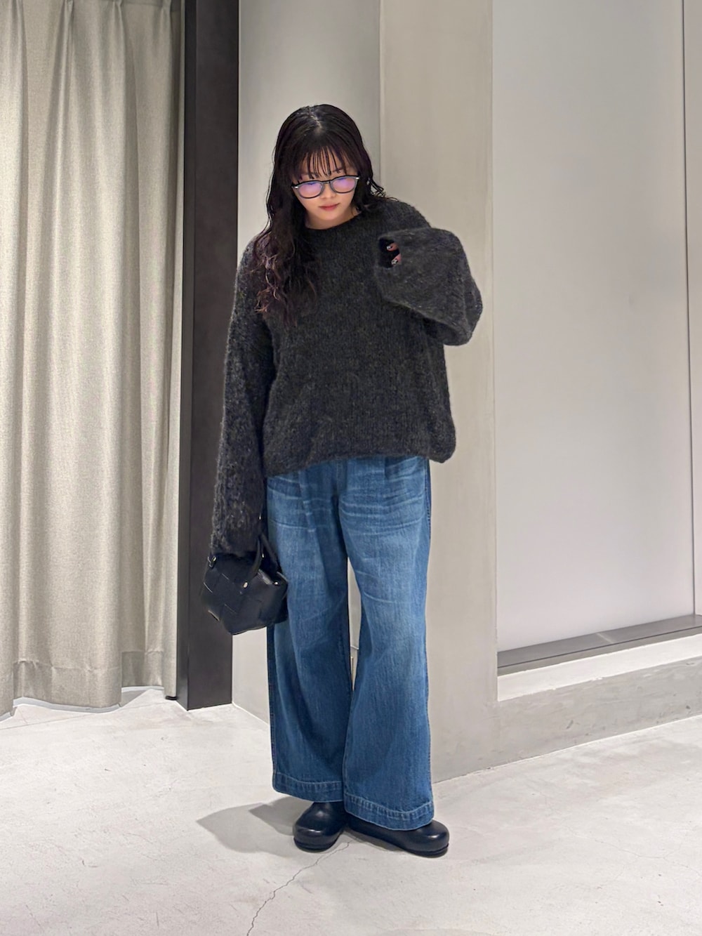 グレー系のニット/セーター、ブラック系のハンドバッグ、ブラック系のその他シューズを着用したレディースの秋コーディネートの4枚目の写真