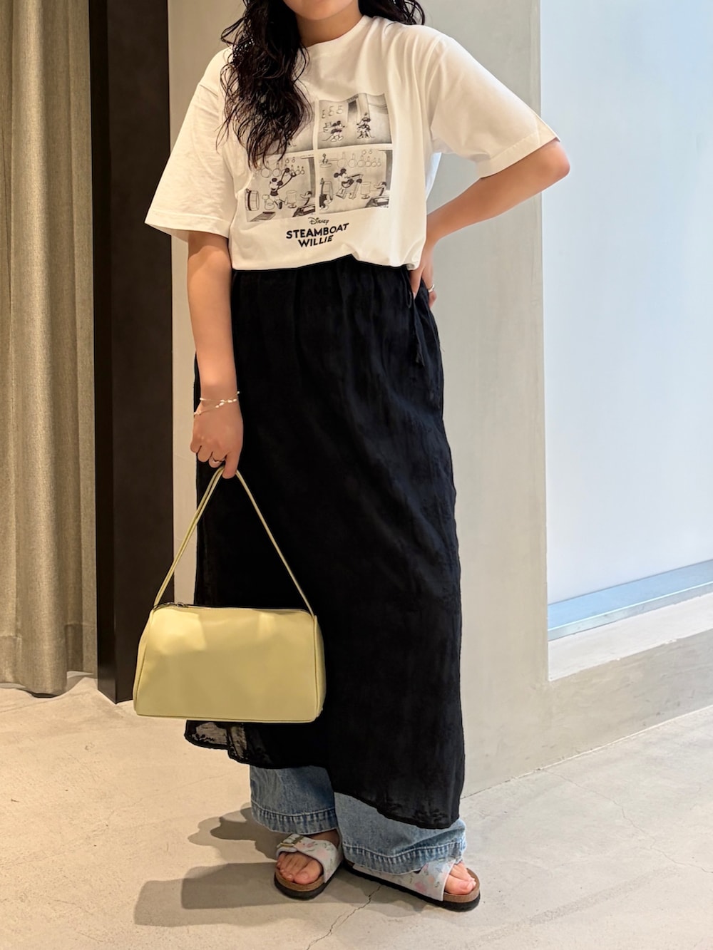 ブラック系のスカート、ブルー系のデニムパンツ、ブルー系のサンダルを着用したレディースの夏コーディネートの3枚目の写真