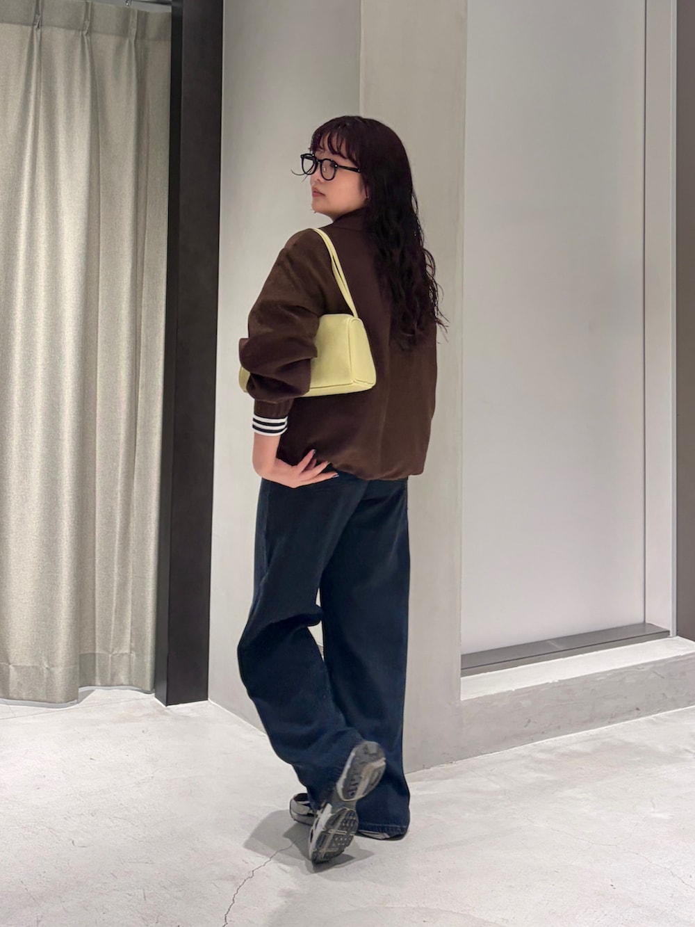 ホワイト系のTシャツ/カットソー、イエロー系のハンドバッグ、ブラウン系のブルゾンを着用したレディースの秋コーディネートの3枚目の写真