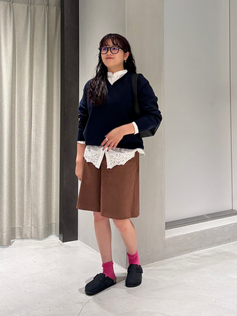 ホワイト系のシャツ/ブラウス、ブルー系のニット/セーター、ブラック系のハンドバッグを着用したレディースの秋コーディネートの6枚目の写真