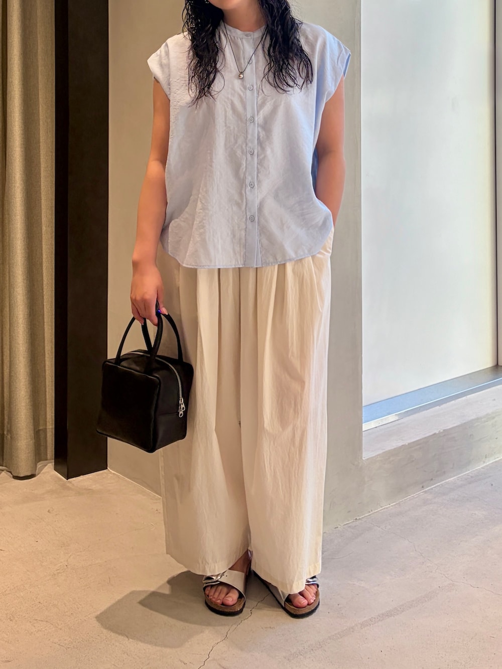 ブルー系のシャツ/ブラウス、ホワイト系のその他パンツ、ブラック系のハンドバッグを着用したレディースの夏コーディネートの5枚目の写真