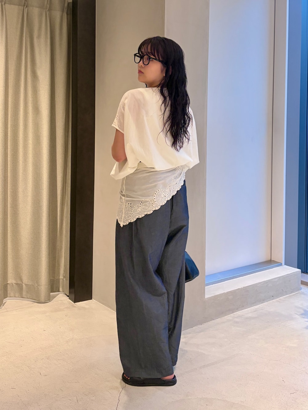 ブラック系のハンドバッグ、ホワイト系のシャツ/ブラウス、ブルー系のデニムパンツを着用したレディースの夏コーディネートの4枚目の写真