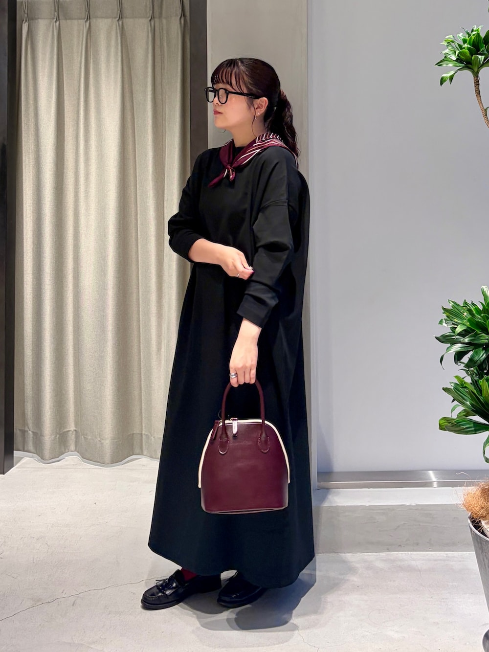 ブラック系のワンピース、レッド系のハンドバッグ、レッド系のバンダナ/スカーフを着用したレディースの秋コーディネートの2枚目の写真