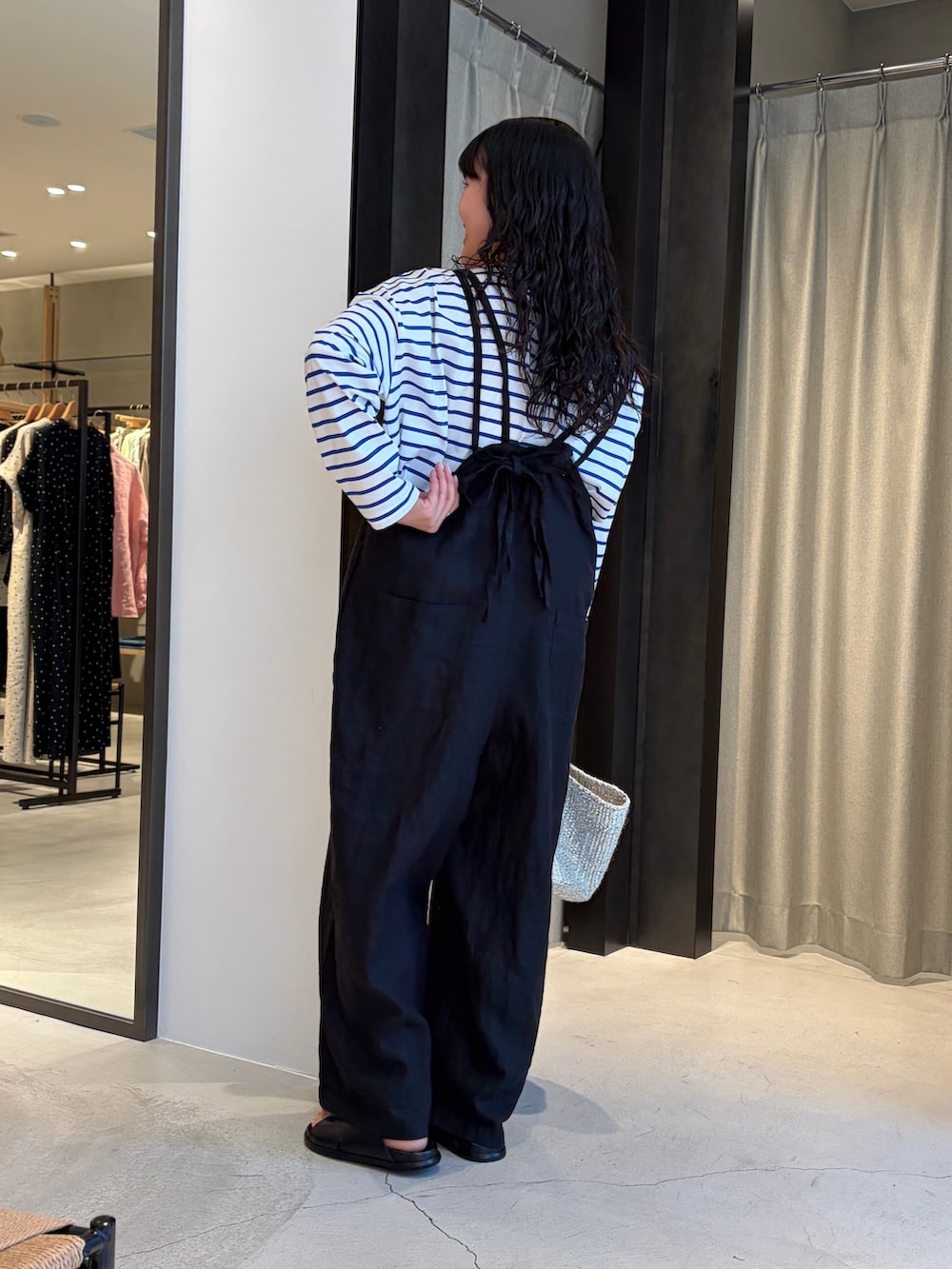 ブラック系のサロペット/オーバーオール、シルバー系のかごバッグ、ブルー系のTシャツ/カットソーを着用したレディースの春コーディネートの4枚目の写真